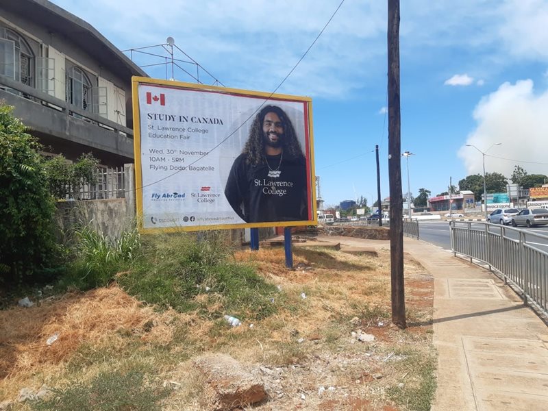 A roadside billboard in Mauritius shows Sean Ozeer in an SLC advertisement.